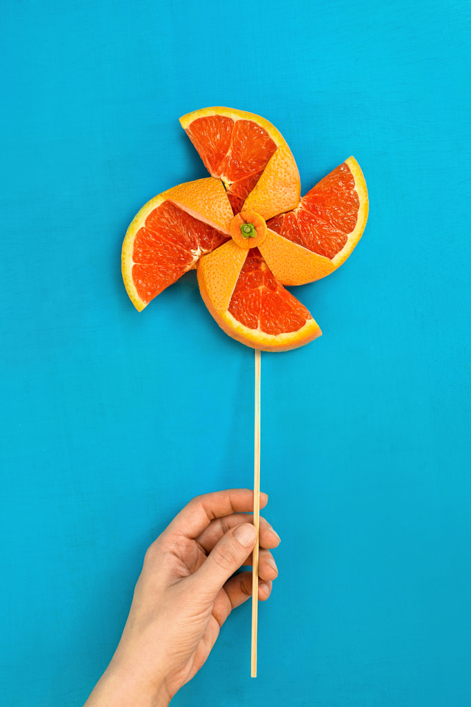 pinwheel made of orange fruit against a blue background